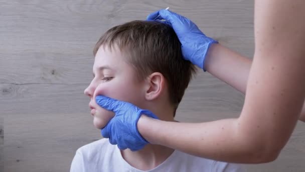 Doktor Otolaryngolog čistí ucho, ušní kanálek dítěte s vatovým tamponem. 4K — Stock video