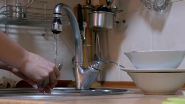 Γυναικεία χέρια πλένουν πιάτα, πιάτα, κουτάλια, πιρούνια σε νεροχύτη τρεχούμενο νερό. 4K — Αρχείο Βίντεο