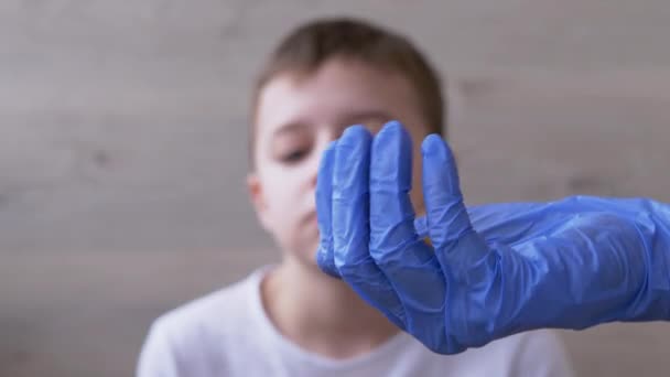 Doctor, un pediatra que usa guantes de nitrilo de látex, le da al niño dos pastillas. 4K — Vídeos de Stock