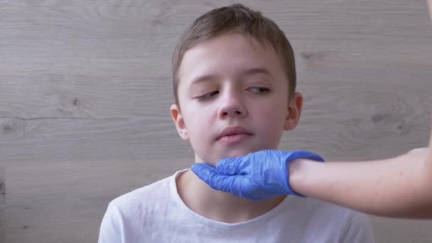 Doctor, ENT, Kinderarts in Latex Nitril Handschoenen onderzoekt mondeling holte van een jongen — Stockvideo