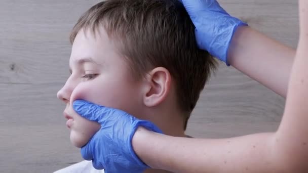 Medico otorinolaringoiatra pulisce le orecchie, canale uditivo di un bambino con un tampone di cotone — Video Stock