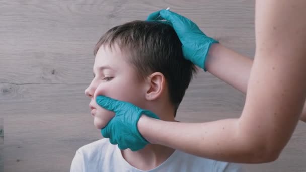 Врач отоларинголог очищает уши, ушной канал ребенка с ватным тампоном. 4K — стоковое видео
