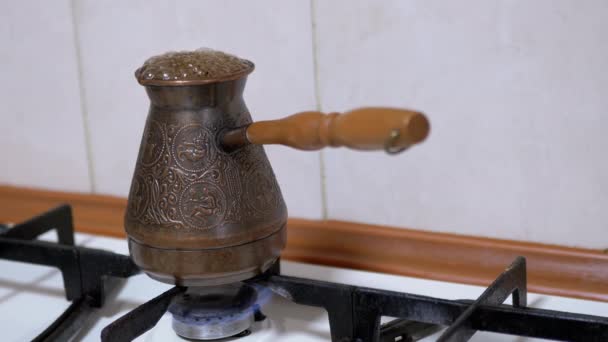 Gemalen Turkse koffie bereiden in een koperen turk op een gasfornuis. 4K — Stockvideo