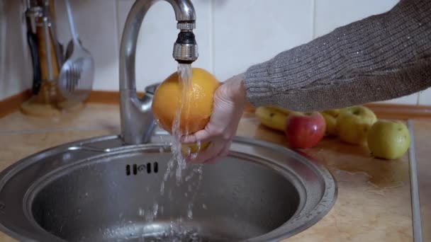 赤いアップル、オレンジ、グレープフルーツを水道水で洗う女性の手 — ストック動画