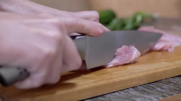 Female Hands Cuts Raw Pork Meat with a Sharp Knife on a Cutting Wood Board. 4K — Video