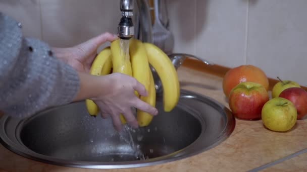 Lavagens Femininas Maduras, Bananas Amarelas com Corrente de Água da Torneira na Cozinha — Vídeo de Stock