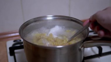 Kadın el spagettiyi karıştırıyor, Makarna tencerede kaynamış su kaşığı