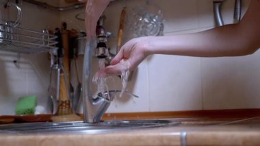 Kadın güçlü bir akarsu deresinin altında ellerini yıkar, musluğu kapatır. Sızıntı. 4K