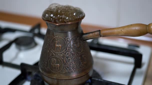 Cocinar café turco molido en un turco de cobre en una estufa de gas. Movimiento lento — Vídeo de stock
