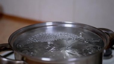 Gaz ocağında paslanmaz tencerede kaynar su. Ev Mutfağı. Yavaş çekim