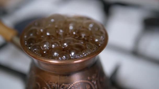 Cocinar café turco molido en un turco de cobre en una estufa de gas. Movimiento lento — Vídeo de stock