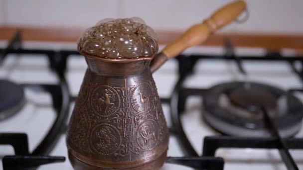 Die Zubereitung von gemahlenem türkischen Kaffee in einem Kupfertürken auf einem Gasherd. Zeitlupe — Stockvideo