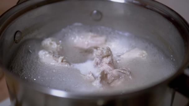 Filetes de pollo hirviendo para caldo en una cacerola en una estufa de gas. Movimiento lento — Vídeos de Stock