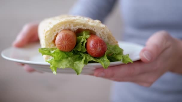 Mujer camarera trae plato jugoso American Hot Dog con salchichas y lechuga — Vídeos de Stock