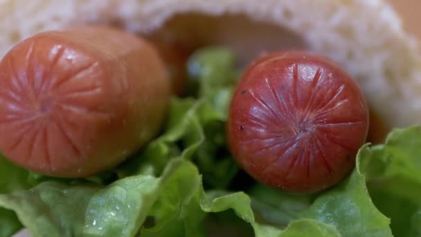 맛있고, 신선하고, 맛있는 미국의 핫도그와 두 개의 소스, 양상추 잎. 줌 — 비디오