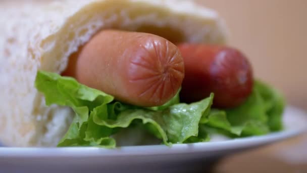 Lahodný, čerstvý, šťavnatý americký hot dog se dvěma klobásami, salátové listy. 4K — Stock video