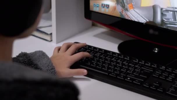 Tiener Gamer in hoofdtelefoon, Zit in een fauteuil, Het spelen van videospellen op de computer — Stockvideo