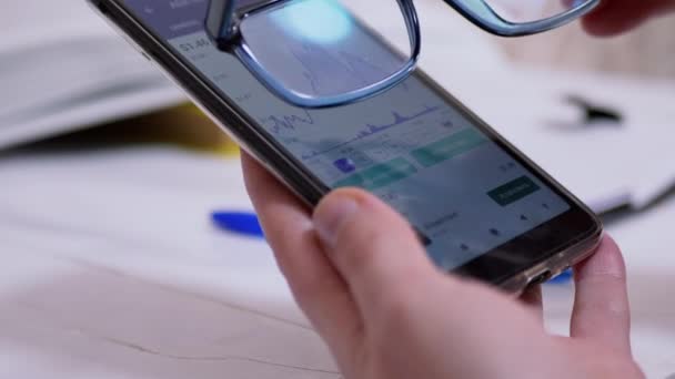 Mänskligt utseende på pris Diagram över Cryptocurrency i Smartphone av Lins of Glasses — Stockvideo