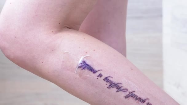 Tatuagem fresca, Letras, Desenho na perna feminina após o procedimento. 4K — Vídeo de Stock