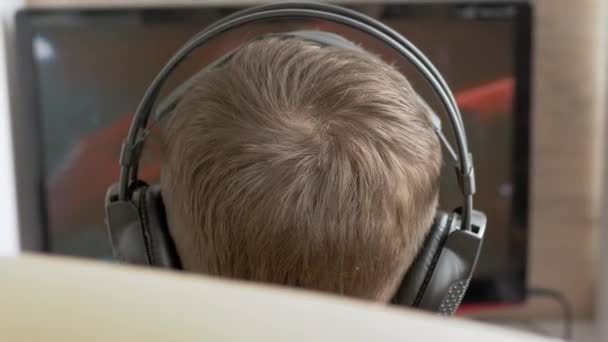 Tonåring Gamer i hörlurar, Sitt i fåtölj, Spela TV-spel på datorn — Stockvideo