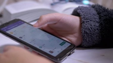 Genç, Bitcoin için bir Fiyat Çizelgesi Görünüyor, Cep telefonunda Kripto Para Birimi