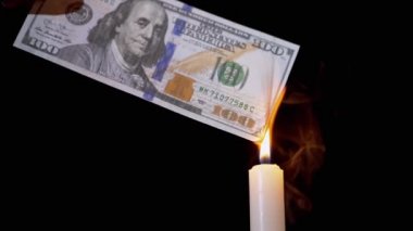 Kara Arkaplan 'da Smoky Candle Alevi üzerine 100 Dolarlık banknot yakmak.