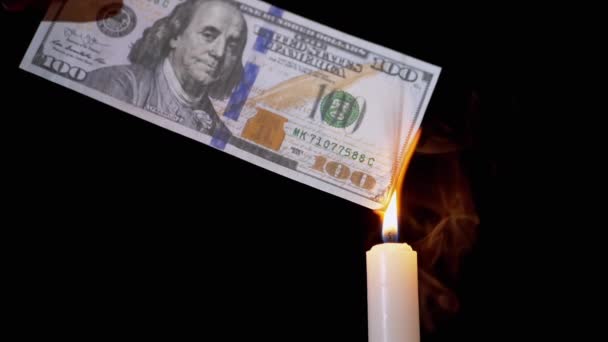 Queimando 100 dólares Bill sobre uma chama de vela fumegante em um fundo preto. — Vídeo de Stock