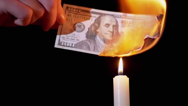 在黑色背景的烛焰下燃烧100美元的钞票 — 图库视频影像