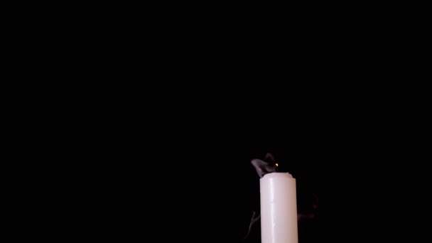 White Paraffin Candle is Blown Out by a Stream of Air on a Black Background — Stock Video