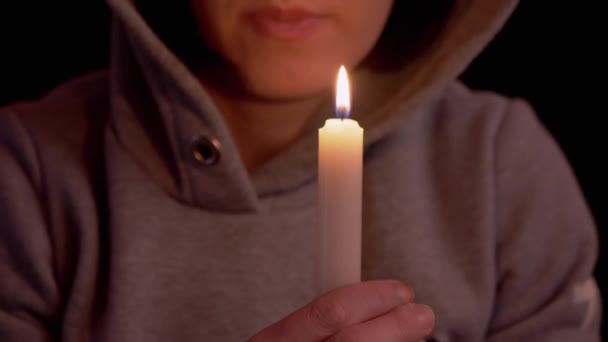 Woman Blows Out a Candle in Hands in a Dark Room. Supplication. Zoom — Stock Video