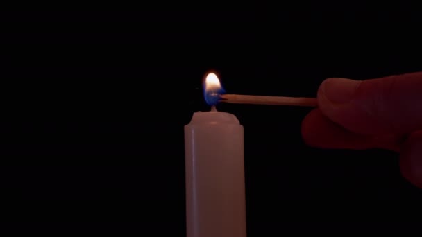 Mannelijke Hand Lights Paraffine Candle met een lucifer op een zwarte achtergrond. 4K — Stockvideo