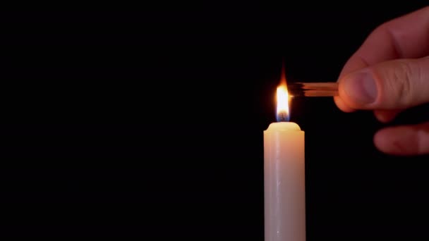 Male Hand Lights Two Matches on a Black Background from a Burning Candle. 4K — Vídeo de Stock