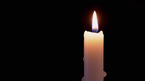 白色石蜡蜡烛燃烧与平静，均匀，火焰，黑色背景的火焰 — 图库视频影像