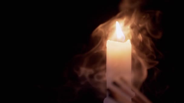 Bougie de paraffine blanche brûlante avec une flamme brillante dans une pièce fumée. Mouvement lent — Video