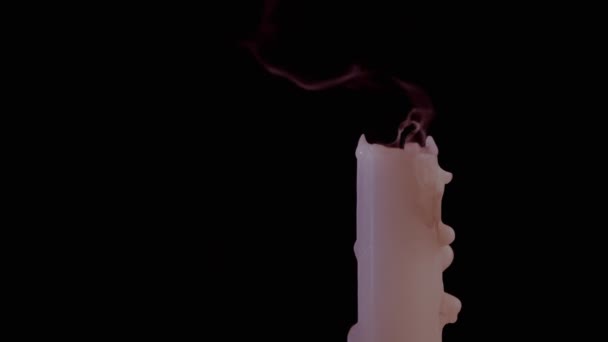 Sopla dos velas de cera con una corriente rápida de aire sobre un fondo negro. — Vídeos de Stock