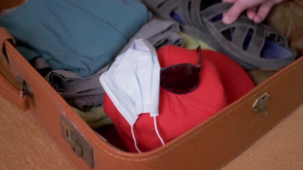 Az Utazó kiveszi a dolgokat egy nyitott, régi, retro barna bőröndből. 4K. Közelről. — Stock videók