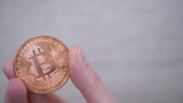 Dedos de persona sosteniendo una moneda de oro de Bitcoin, criptomoneda. 4K. De cerca. — Vídeos de Stock