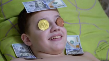 Gülümseyen Genç Yalan Söylüyor, Dolarlı Yatakta, Gözlerinde Altın Bitcoin. Mizah. 4K