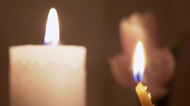 Mum ve Kilise Mumları Solan Çiçeklerin Arkaplanına Karşı Alevle Yanar