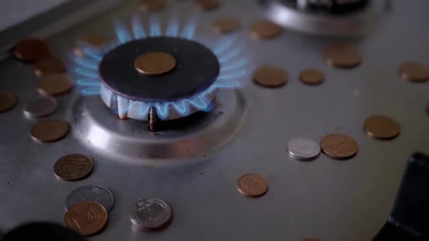 Munten Vallen op Gas brander, die gloeien met een blauwe vlam in de keuken. 180 fps — Stockvideo