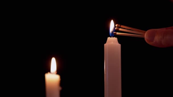 Muž ruka světla tři zápalky na černém pozadí z hořící svíčky — Stock video