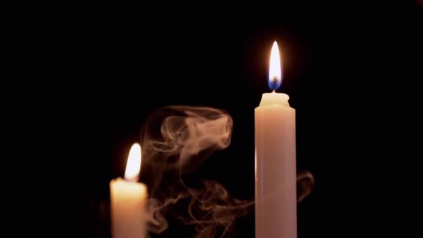Dvě hořící bílé parafinové svíčky s jasným plamenem v kouřové místnosti — Stock video