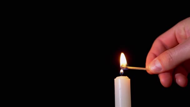 Mužské ruční světla Parafínová svíčka pomocí zápalky na černém pozadí. Pomalý pohyb — Stock video