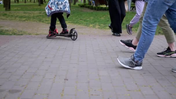 Pies de personas, transeúntes a pie sobre losas de pavimentación en el parque. Movimiento lento — Vídeo de stock