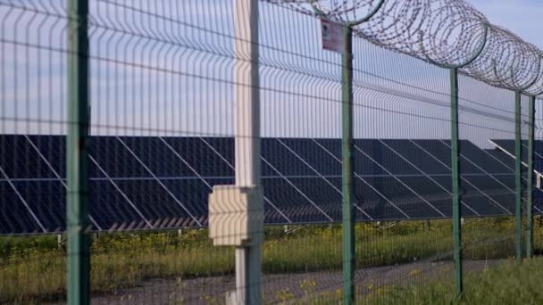 Painéis solares cercados com cerca de arame farpado. Pilhas solares. 4K — Vídeo de Stock