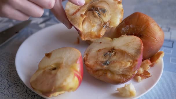 Женщина указывает пальцем на заплесневелые яблоки на тарелке. Порезы, испорченные, плесени фрукты. 4K — стоковое видео