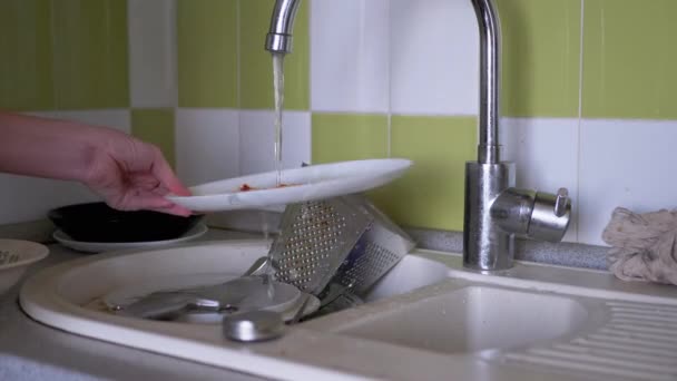 Female Hands Wash Dirty Plates in Kitchen Sink Under Running Water. 4K — Stock Video