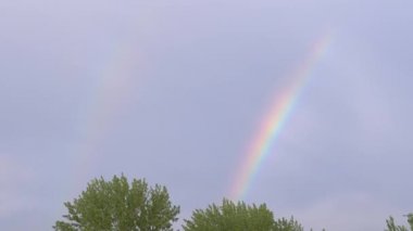 Gökyüzündeki Gri Bulutlar aracılığıyla Horizon 'da Çifte Parlak Gökkuşağı. Büyüt