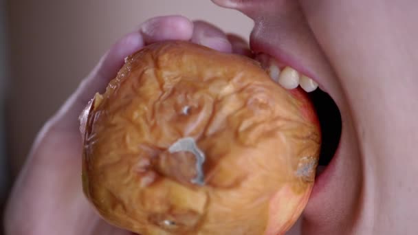 Frau beißt mit Zähnen ein Stück vom faulen Apfel ab Verdorbenes, verschimmeltes Obst — Stockvideo