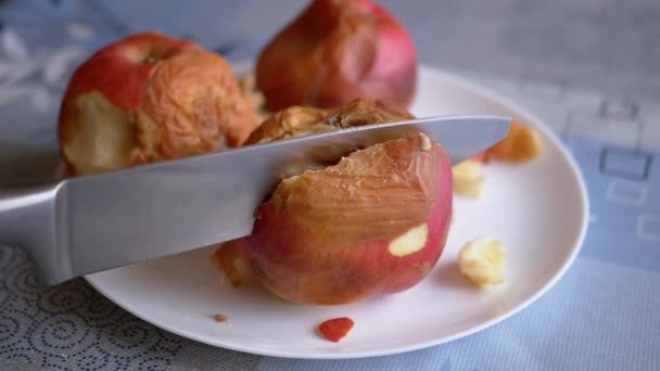 女性の手ナイフで皿の上にロッテンアップルをカットします。こぼれた、カビの果実 — ストック動画
